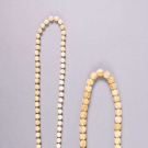 TWO CARVED FIGURAL OR FLORAL MOTIF NECKLACES