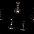 FIVE STERLING OVERLAY PERFUME BOTTLES, c. 1900